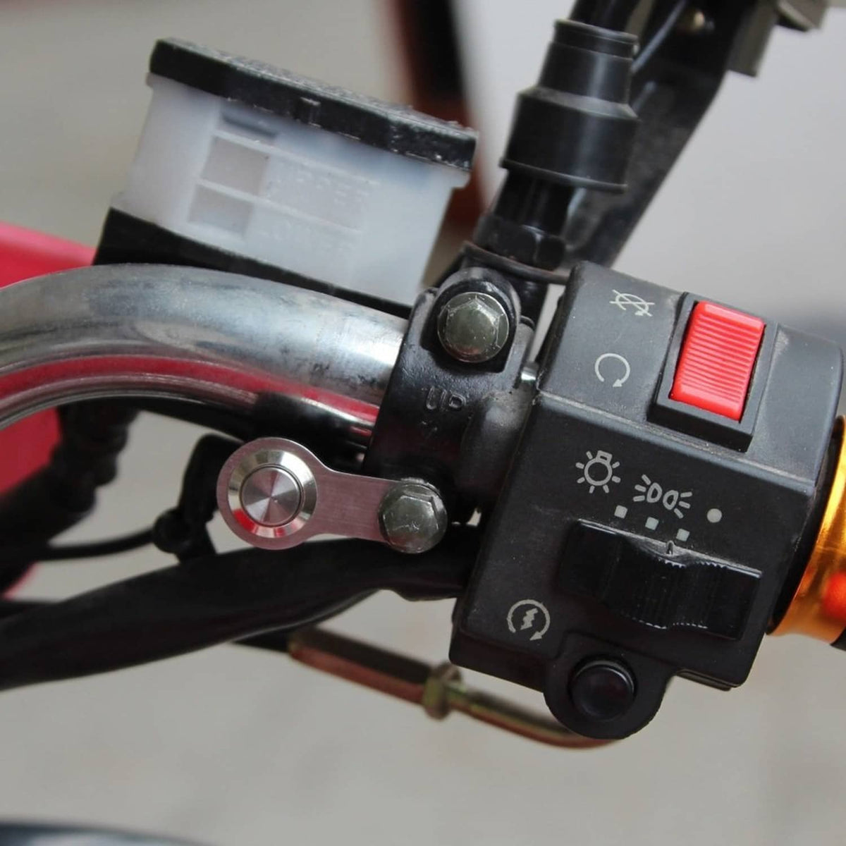 Motorcycle control switch with small metal round button and red rocker indicator