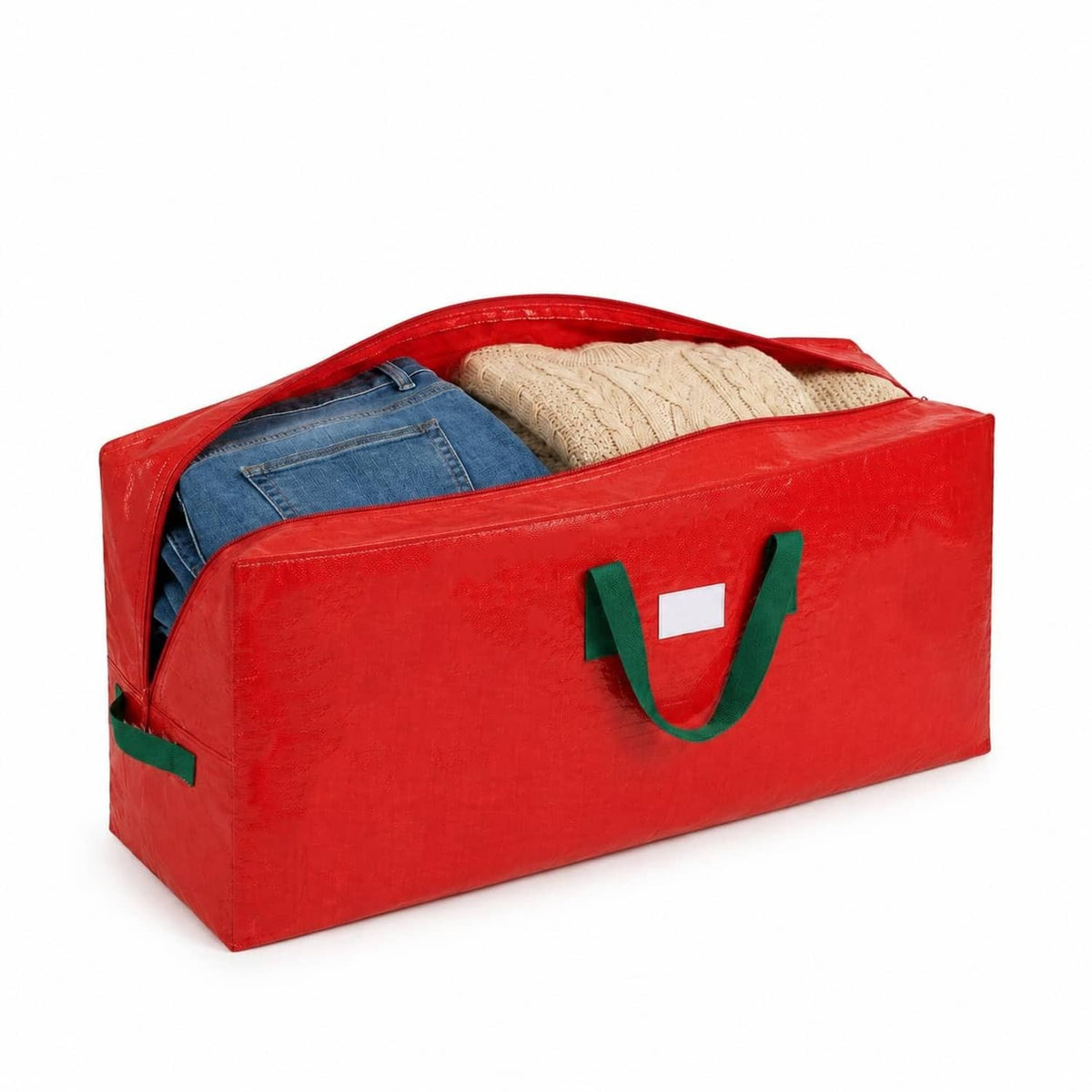 Red Christmas tree storage bag with green handles, filled with folded blankets or linens