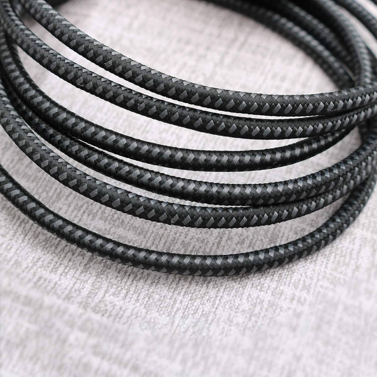 Close-up of braided black USB-C cable jacket texture, short USB-C to USB-C leads