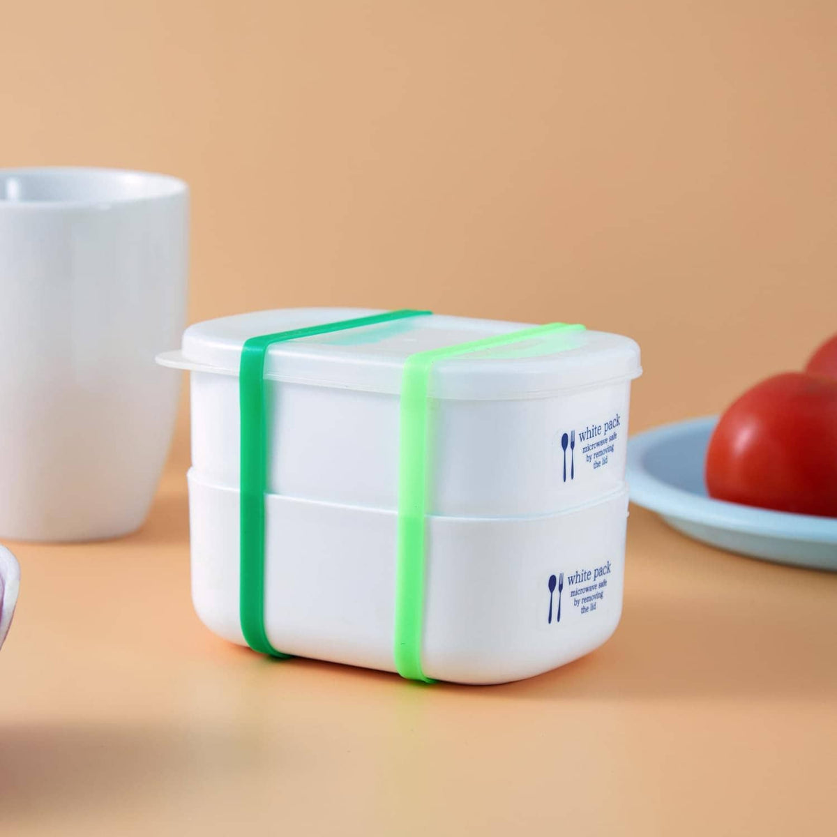 Silicone elastic bands inside a white container with green straps, curved loop bands