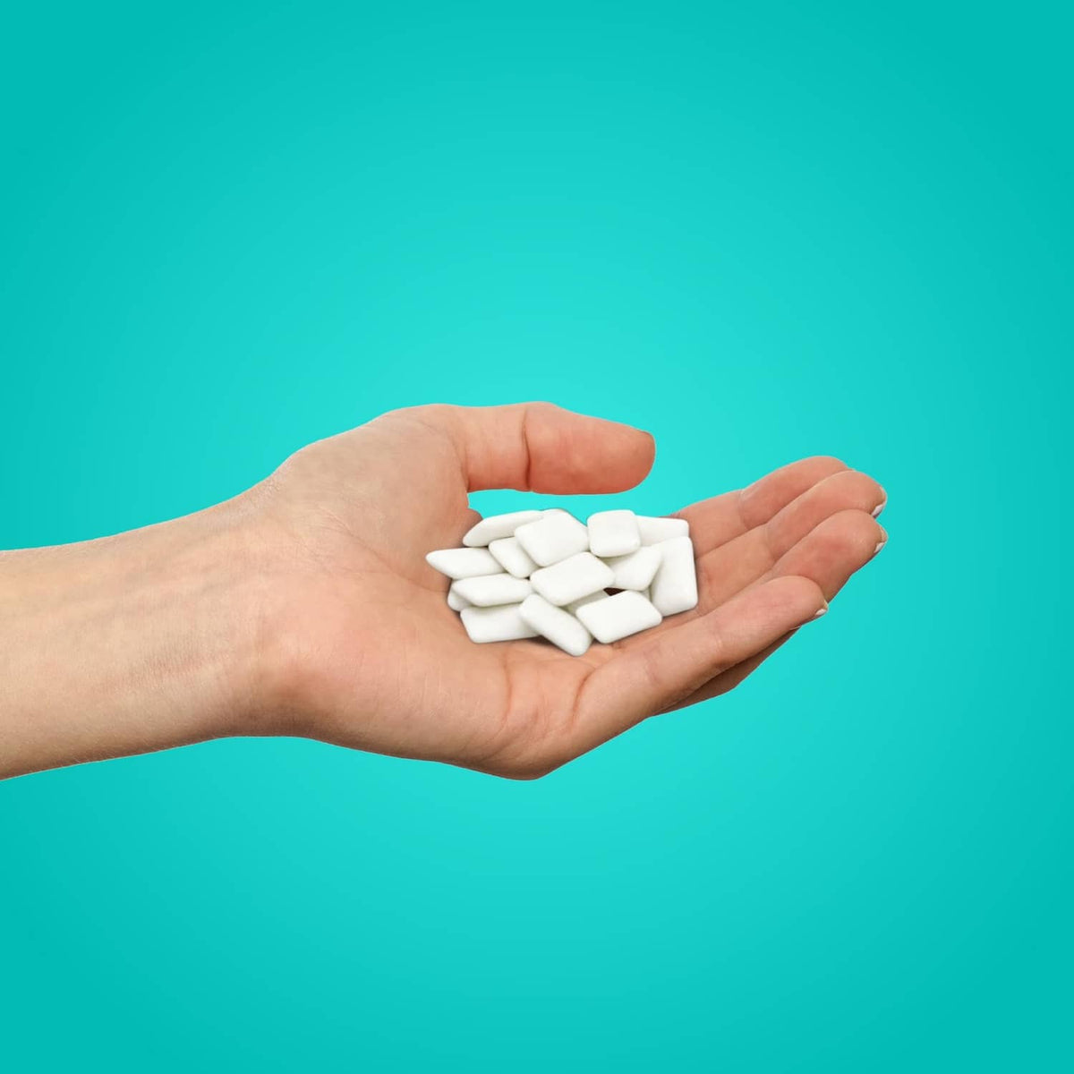 Wintergreen xylitol gum pieces in hand, PUR