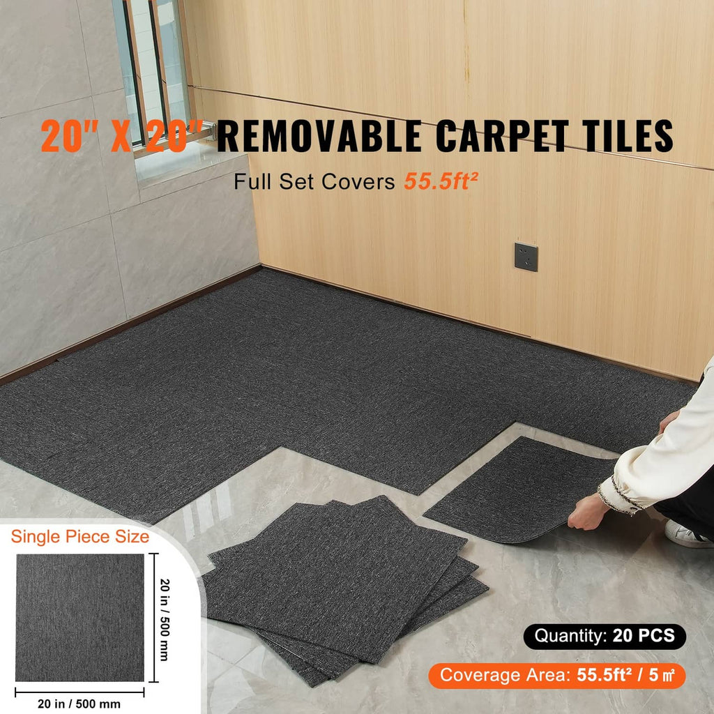 Dark gray removable carpet tile squares laid on the floor with loose tiles nearby