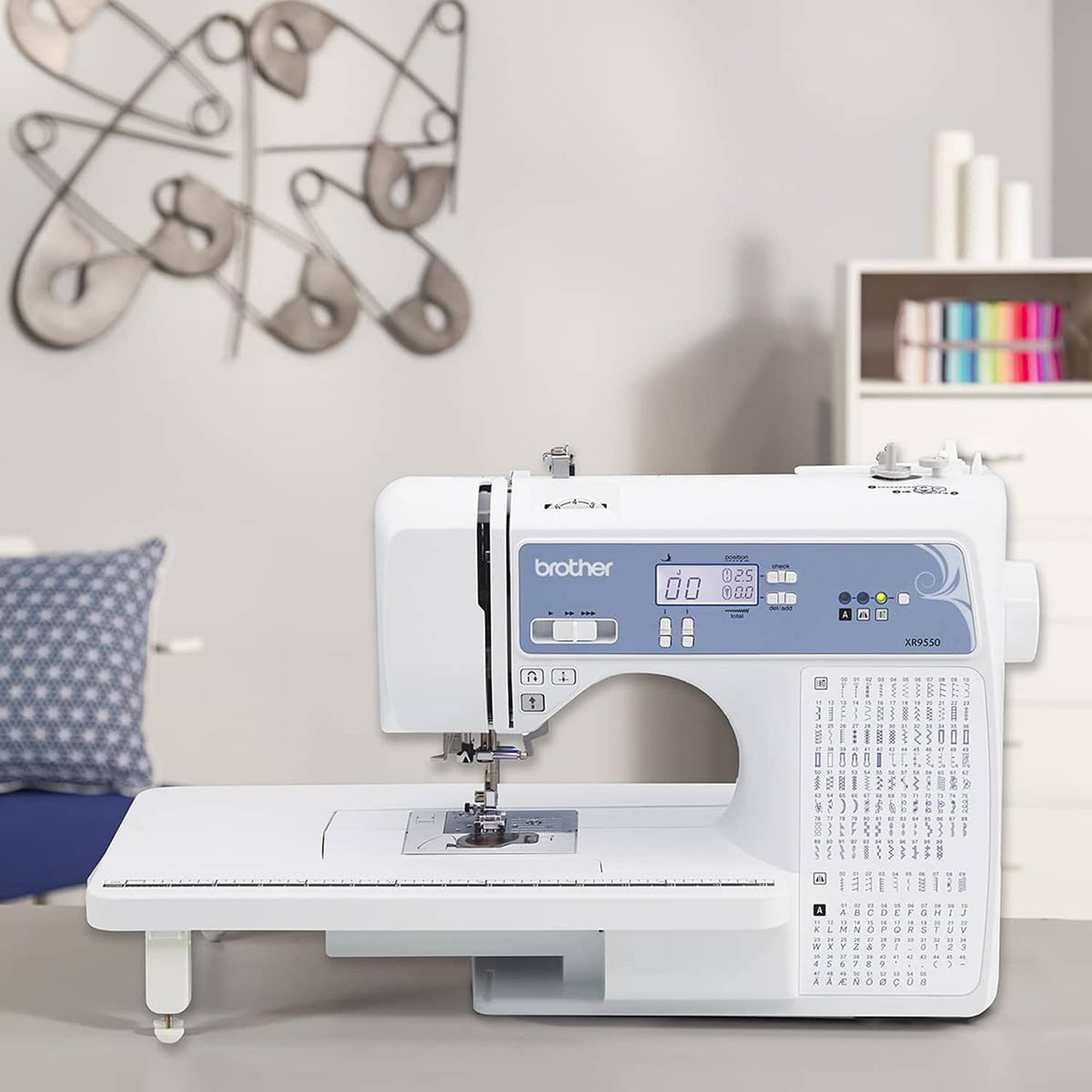 White computerized sewing and quilting machine on a worktable with front controls visible.
