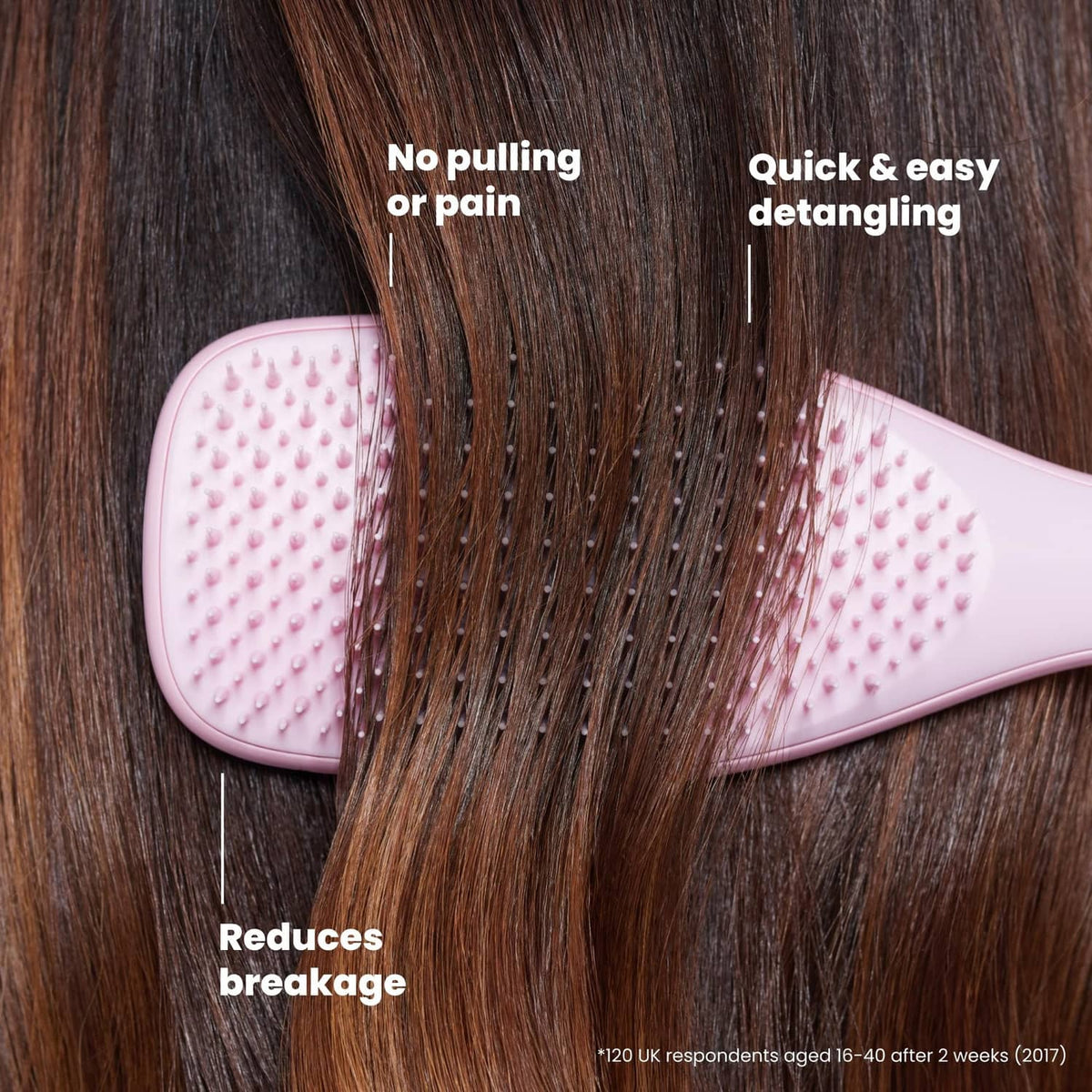 Pink detangling hairbrush with rounded cushion head and bristles on hair