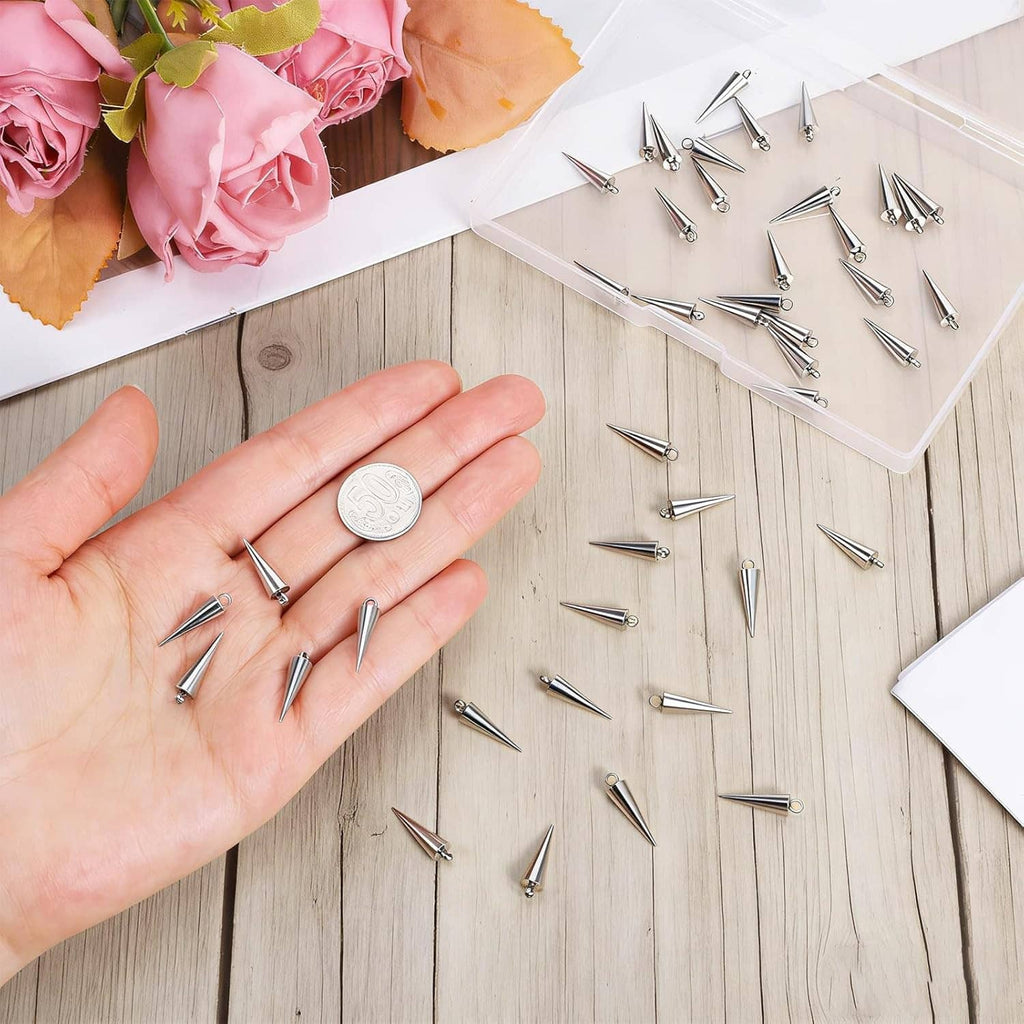 Hand holding stainless steel spike cone charms, small conical spikes with open loops
