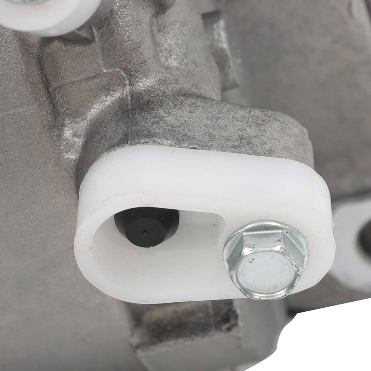 A/C compressor close-up of white plastic connector cover on silver housing