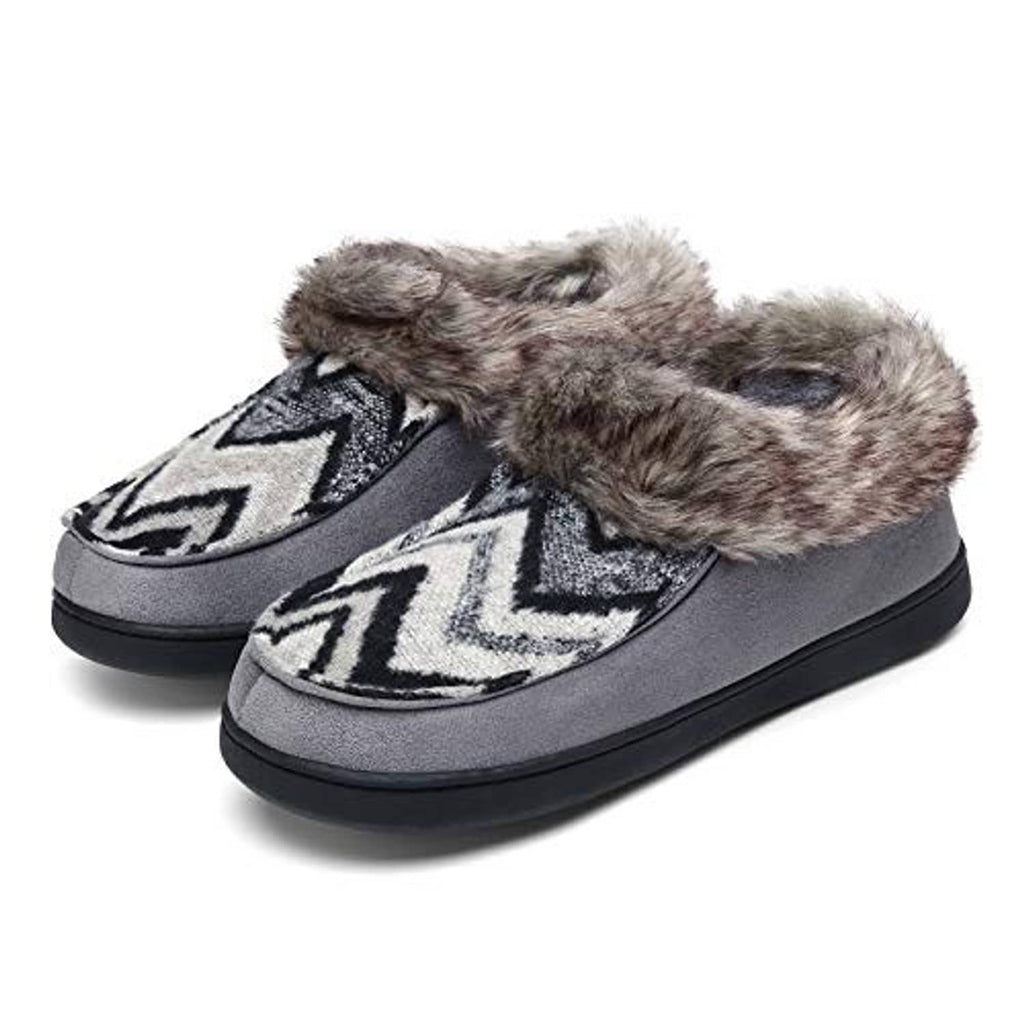 Pair of grey moccasin house slippers with plush faux-fur cuff and zigzag patch, black outsole.