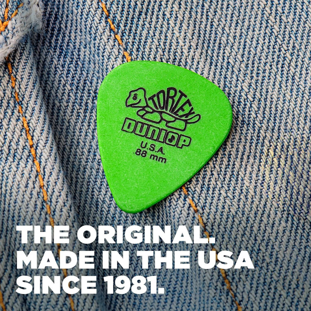 Green Dunlop Tortex guitar pick on denim, U.S.A., .88 mm, with logo text.