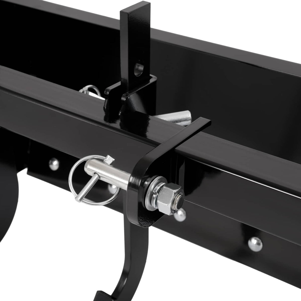 Close-up of latch pin and black scraper blade crossbar on tow-behind attachment