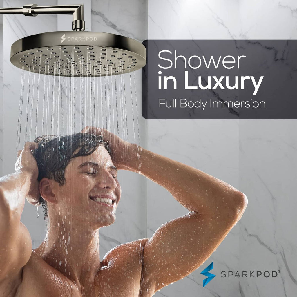 Brushed nickel rain shower head overhead with water streaming onto the user’s shoulders