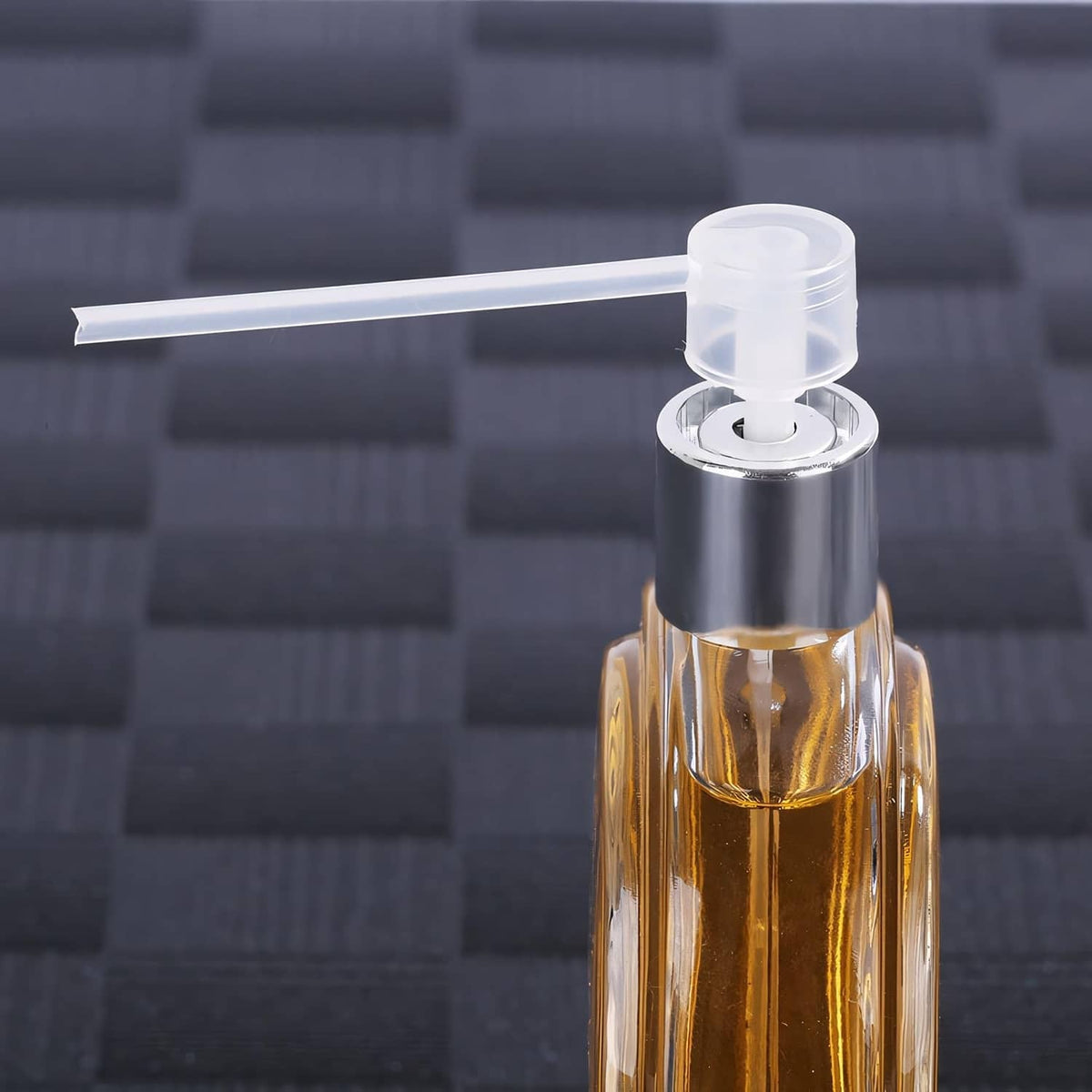 Clear pump applicator inserted into perfume bottle opening with transfer tube