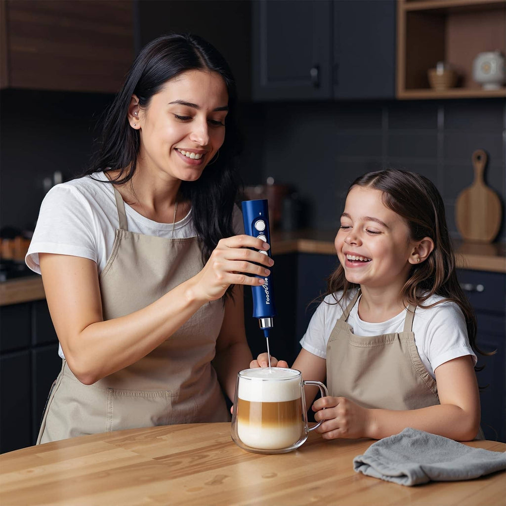 Blue handheld milk frother held above a mug for creating milk foam.