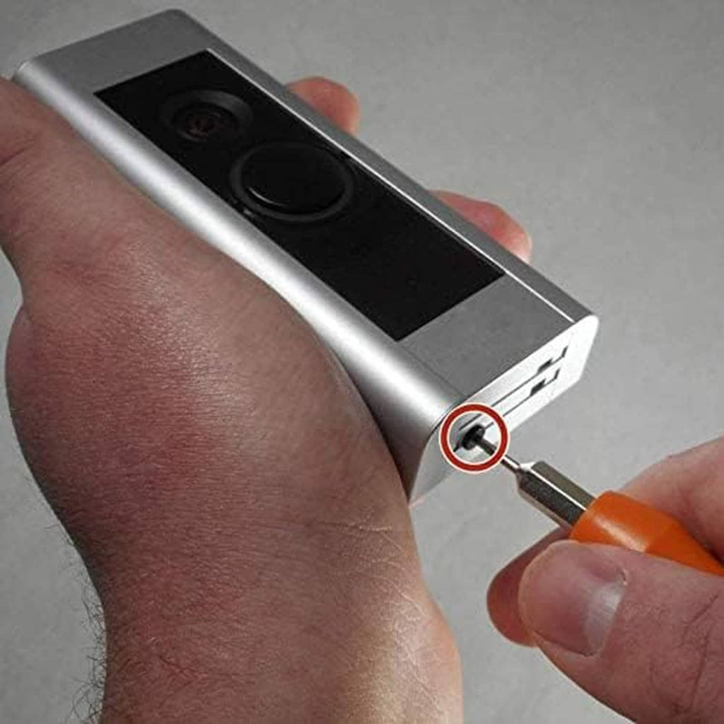 Orange-handled Torx screwdriver tightening a screw on a doorbell faceplate
