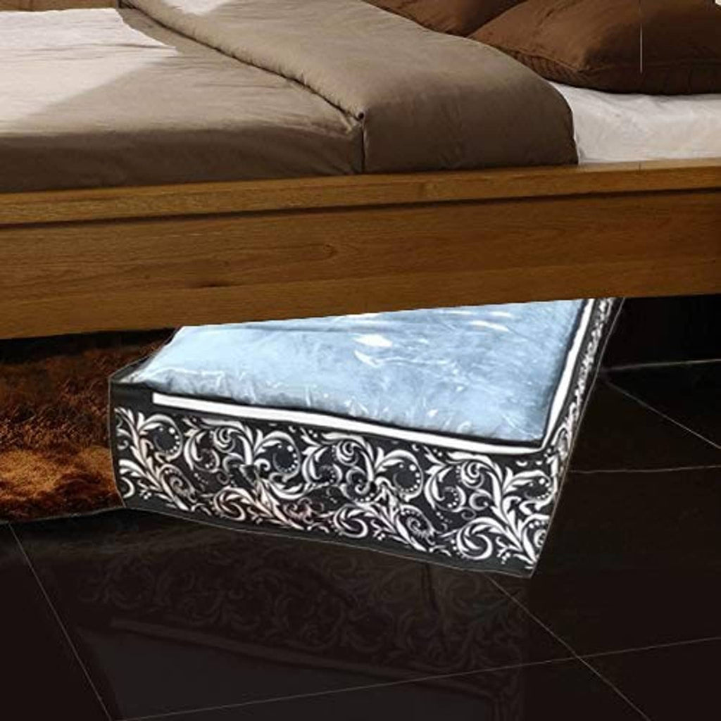 Under-bed storage bag under bed on floor, blue insert and black scroll-pattern sides
