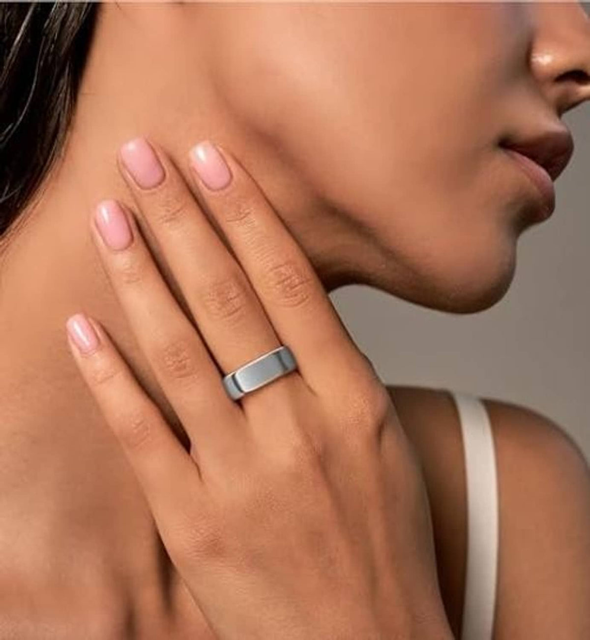 Ring cover on a finger, silver band with light-gray center strip.