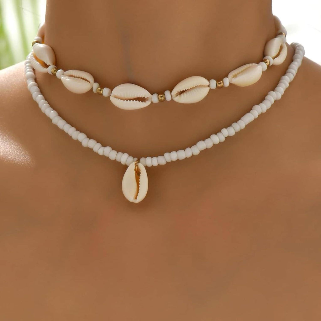 Cowrie shell necklace with white bead chain and central drop shell, gold-tone beads