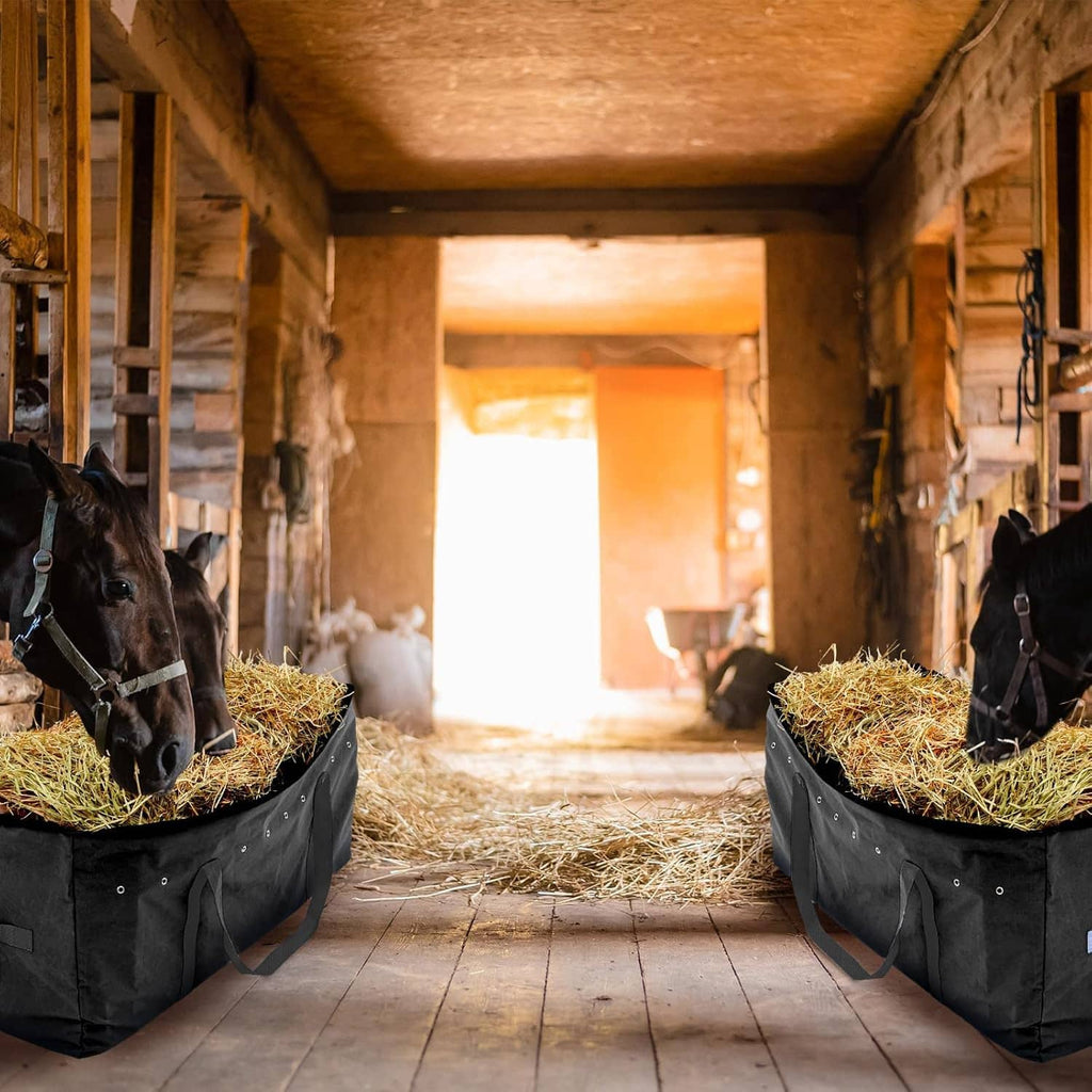 Pair of black hay storage bags with hay bales inside and carry handles for feeding