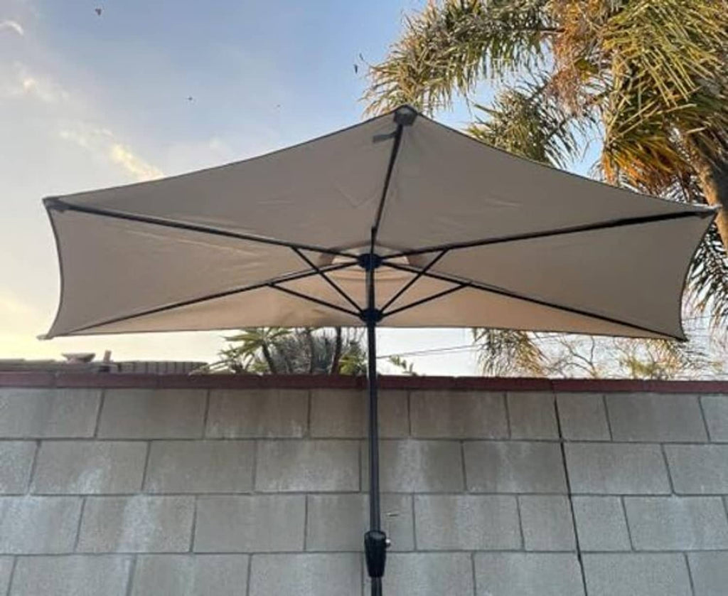 Tan umbrella canopy with black rib frame and central pole