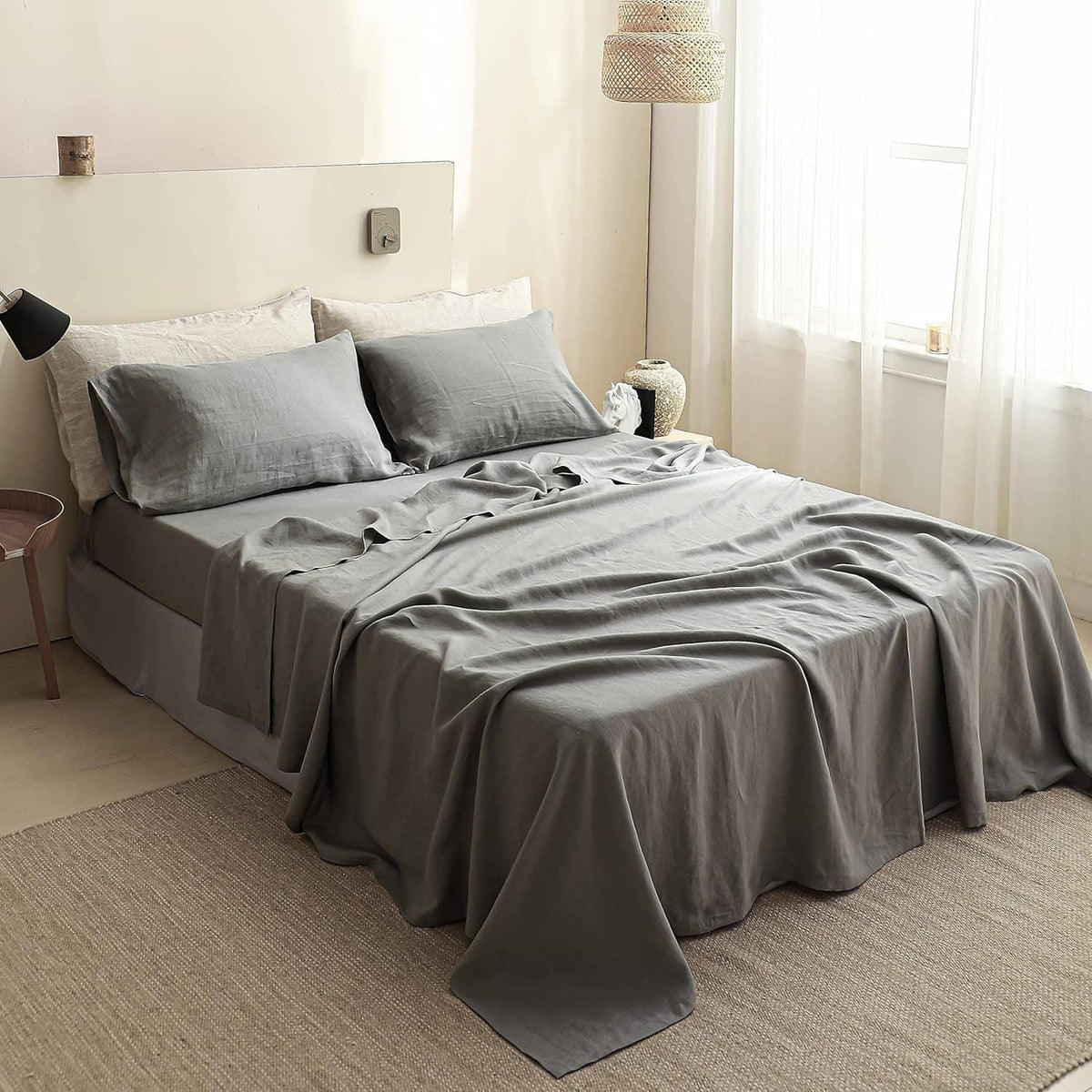 Gray linen fitted mattress cover covering mattress with elastic corners