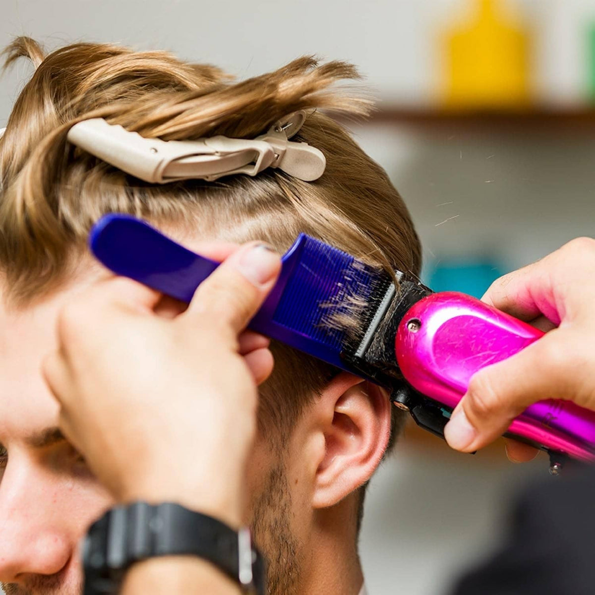 Blue fine-tooth comb used with heat styling near the ear and hair