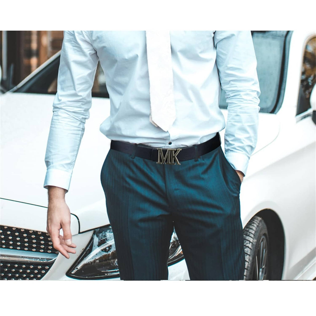 Black leather belt with gold buckle worn at waist over dark trousers