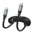 Coiled black USB-C to USB-C charging cable with two metal USB-C connectors, close-up