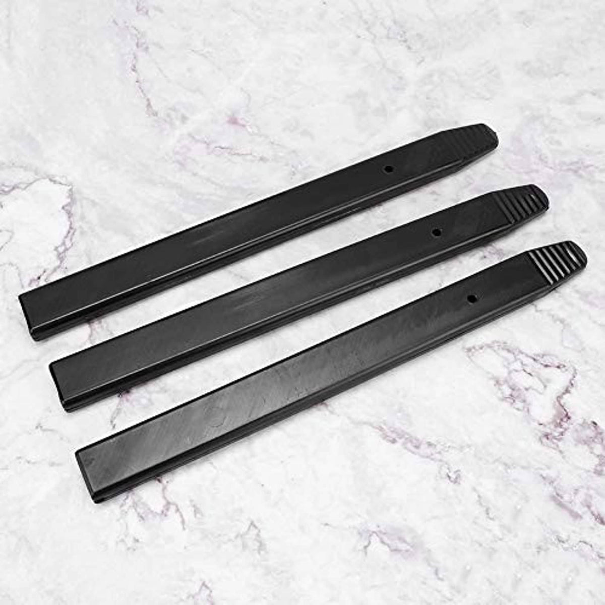 Three black tire bead cover sleeves with holes and ribbed end grips