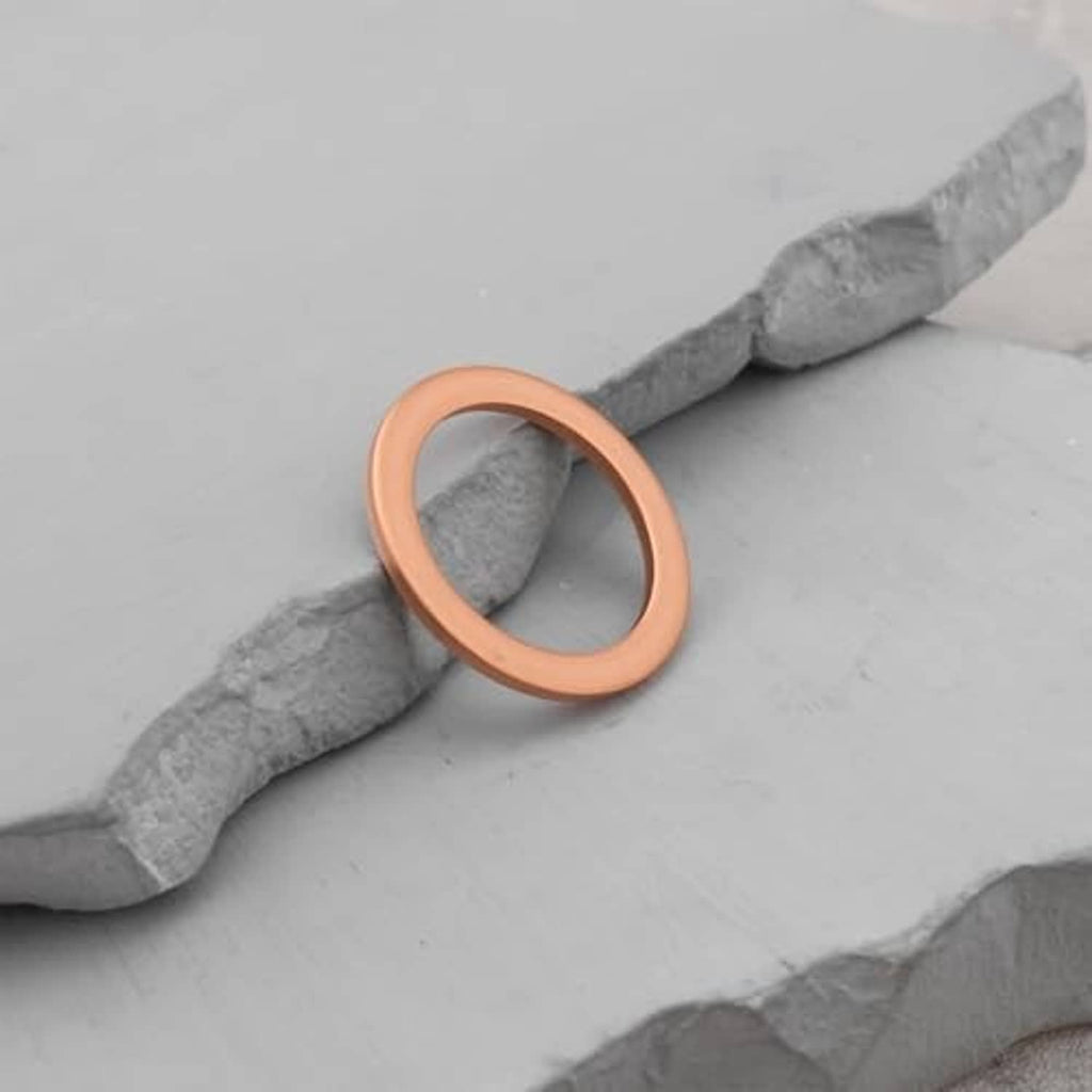 Brown gasket washer ring on gray surface, round sealing loop