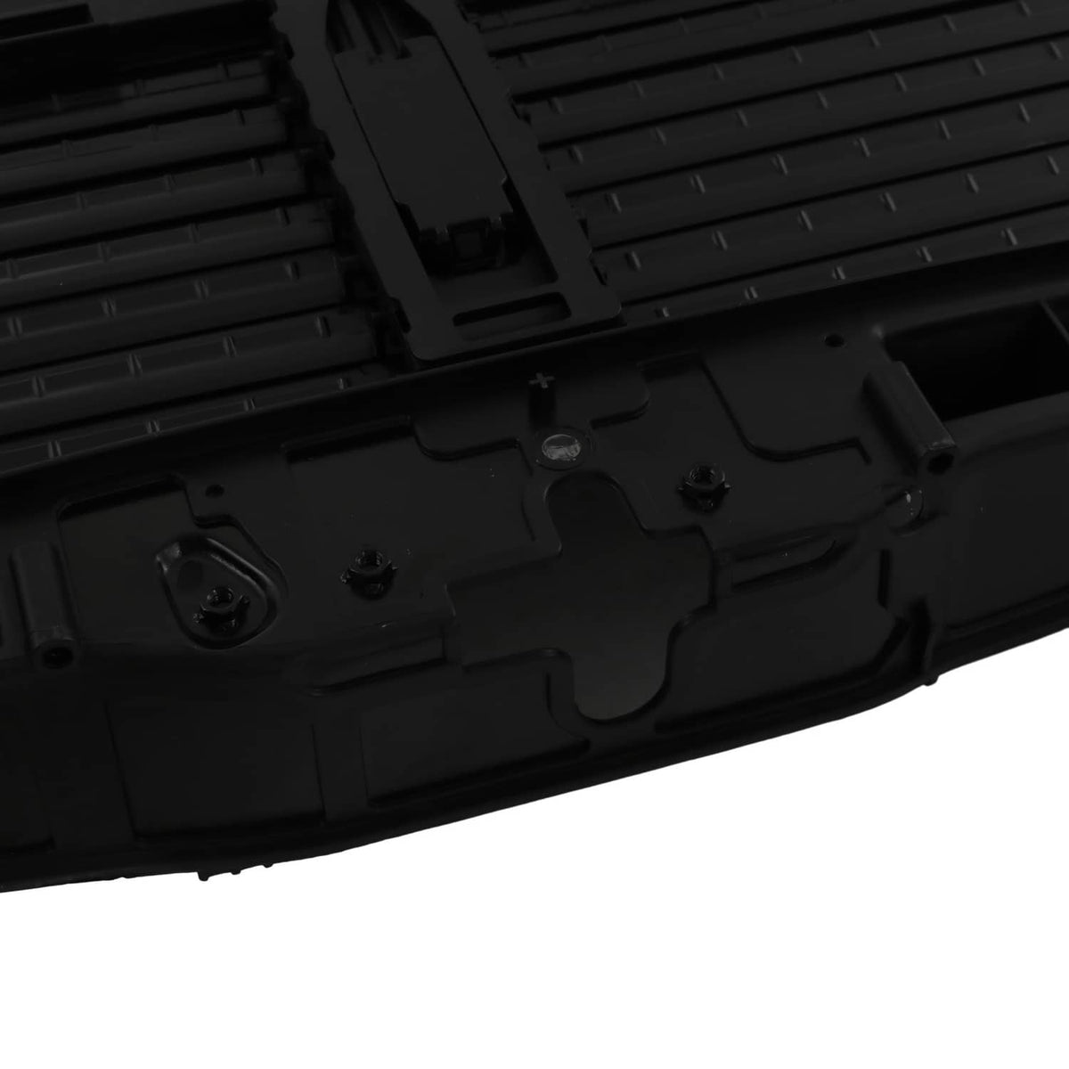 Close-up of black air shutter grille base with screw holes and latch contours