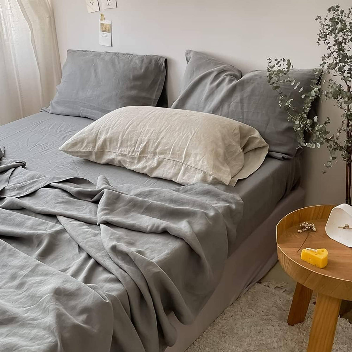 Gray linen fitted mattress cover on twin mattress with pleated fitted skirt