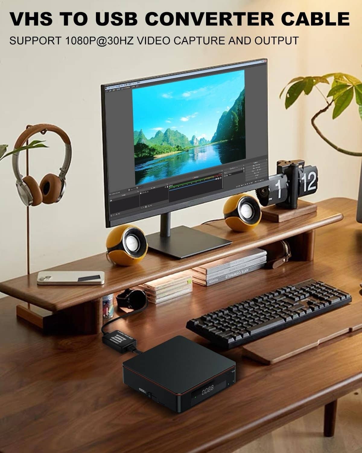 Black VHS-to-USB converter box with AV cables on a home desk setup