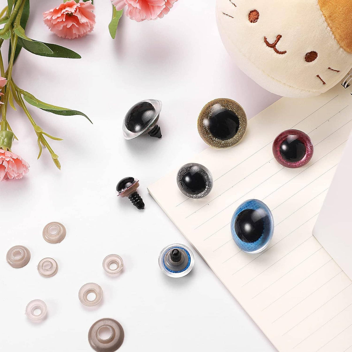 Assorted glitter safety eyes with screw backs and washers on a craft page