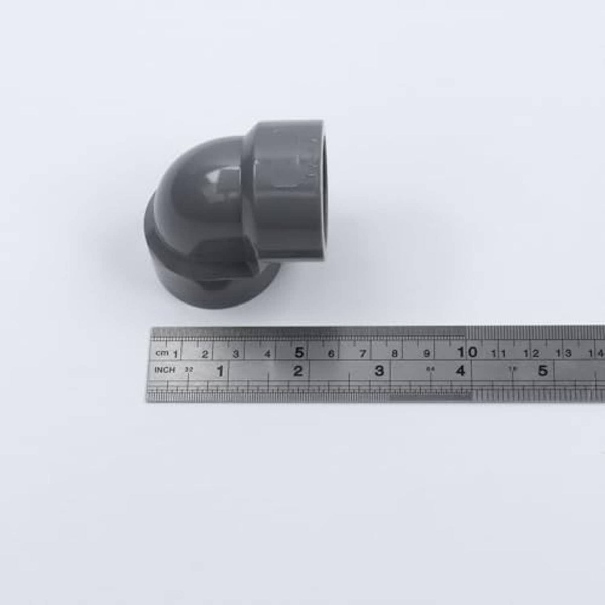 Gray PVC 90-degree elbow adapter with size ruler, female threaded ends
