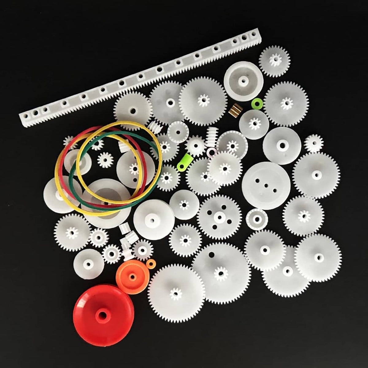 Plastic gear kit with white gears, small axles, and colored belt loops