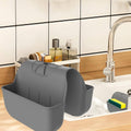 Gray silicone sponge caddy with open front and side wing on sink counter