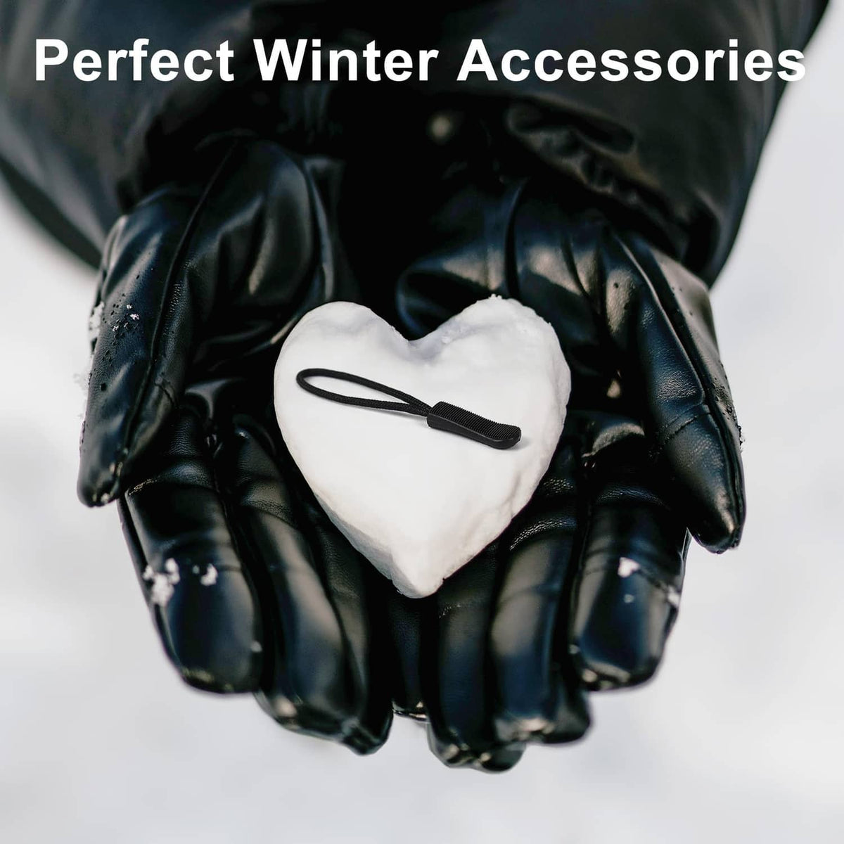 Black zipper pull tab with cord on a heart-shaped pouch held by gloves