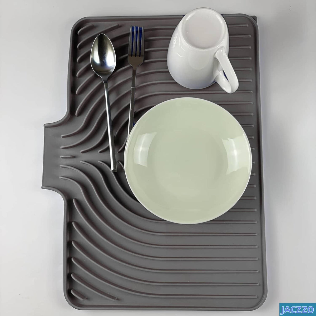 Gray dish drying mat with ribbed surface holding spoon, fork, cup, and plate for drying