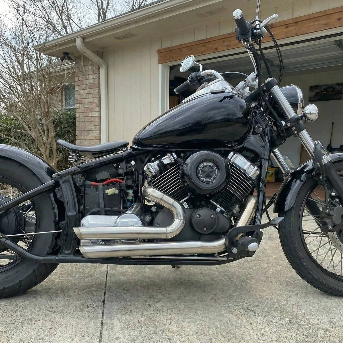 Motorcycle staggered exhaust pipe set in chrome finish with mufflers and brackets