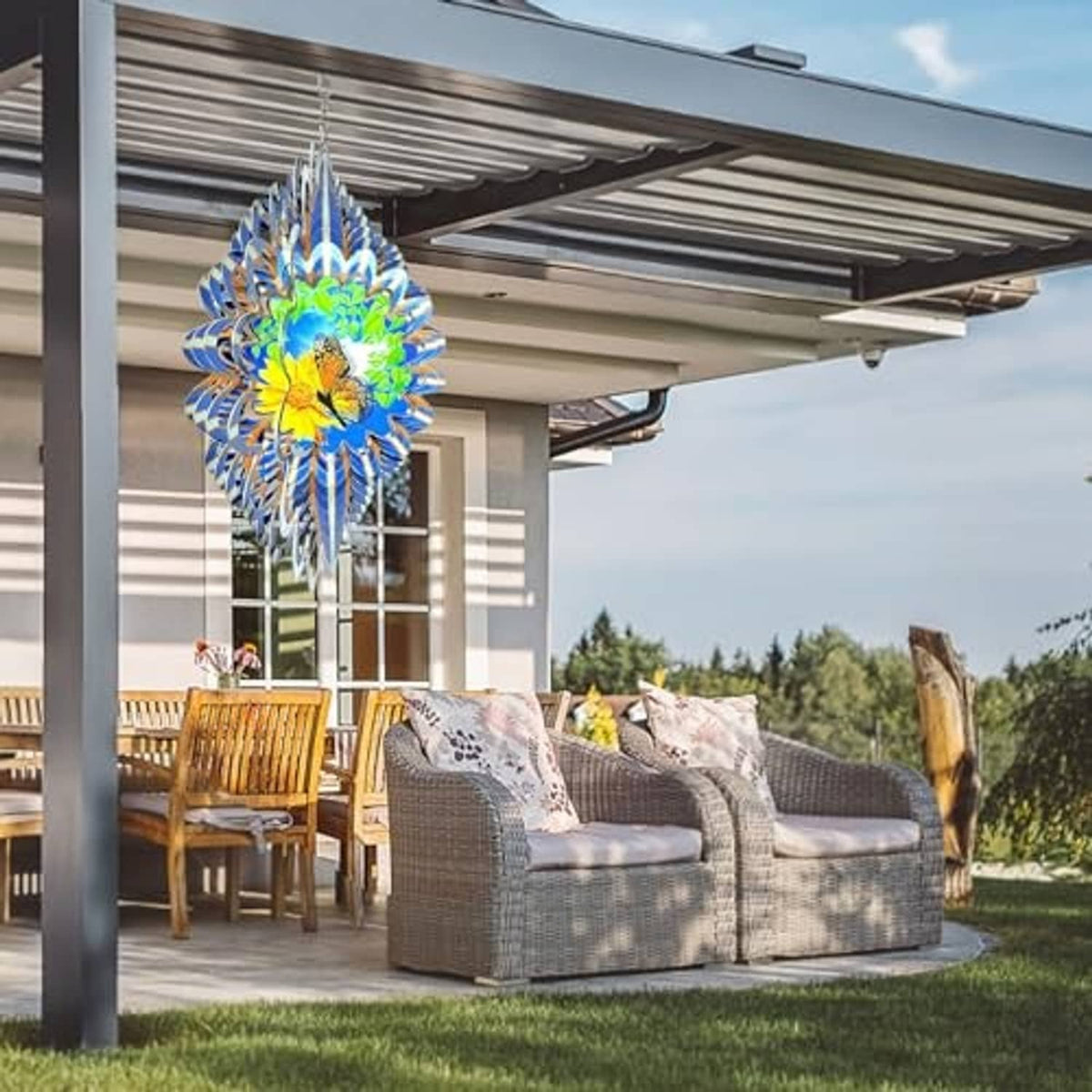 Hanging butterfly wind spinner with blue, green, and yellow vanes under a patio