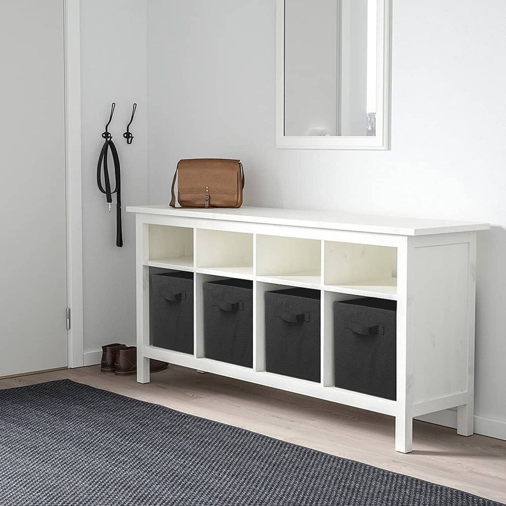 Black fabric storage cubes with front pull handles in a white cabinet