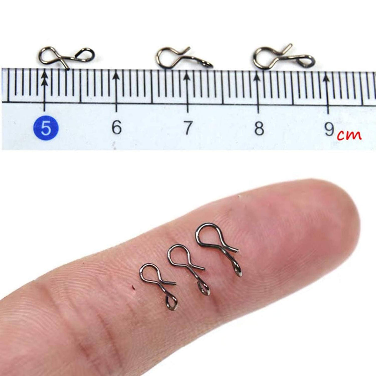 Fly snap hooks, three silver clips shown in hand with a size ruler for scale