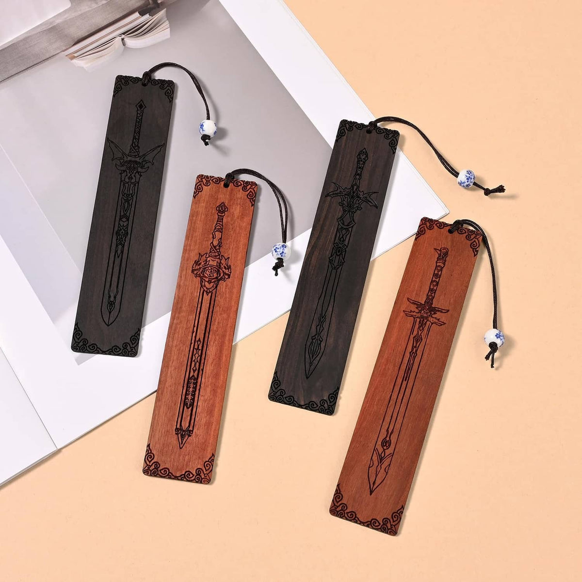 Set of four sword bookmarks with lanyards, black and brown designs on white sheets