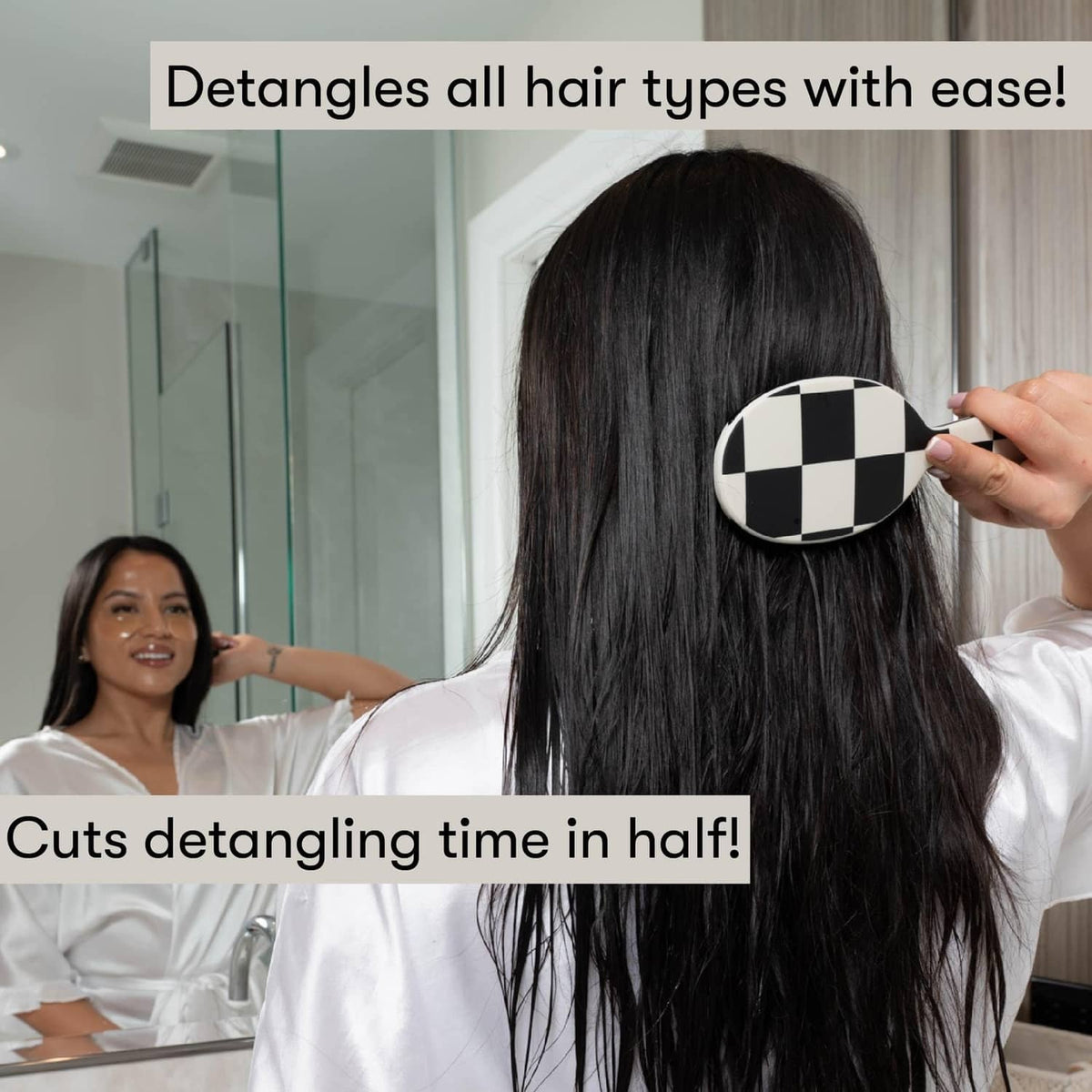 FRAMAR detangling hair brush held to smooth long dark hair, oval black bristle pad