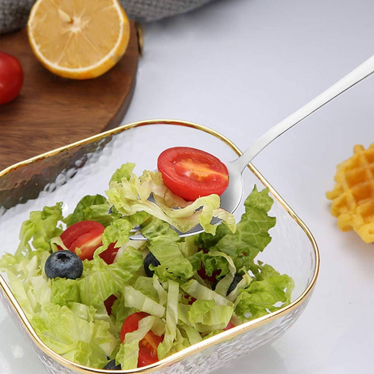 Stainless steel spork lifting mixed salad with lettuce and tomato
