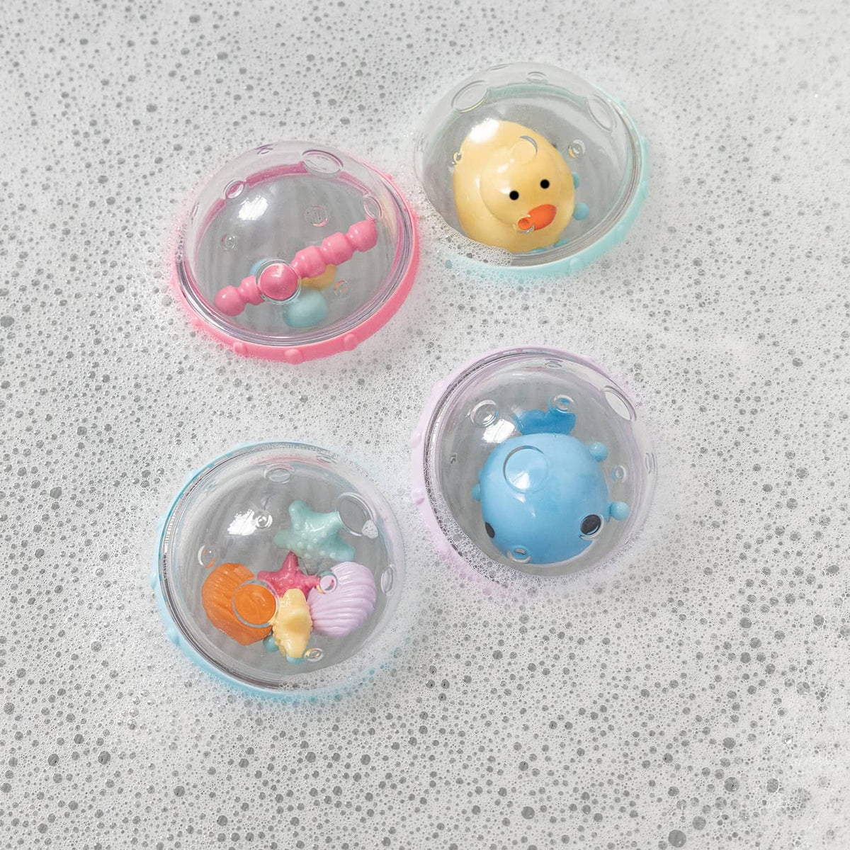 Four clear bubble float toys with pink seahorse, yellow duck, orange fish, and blue whale
