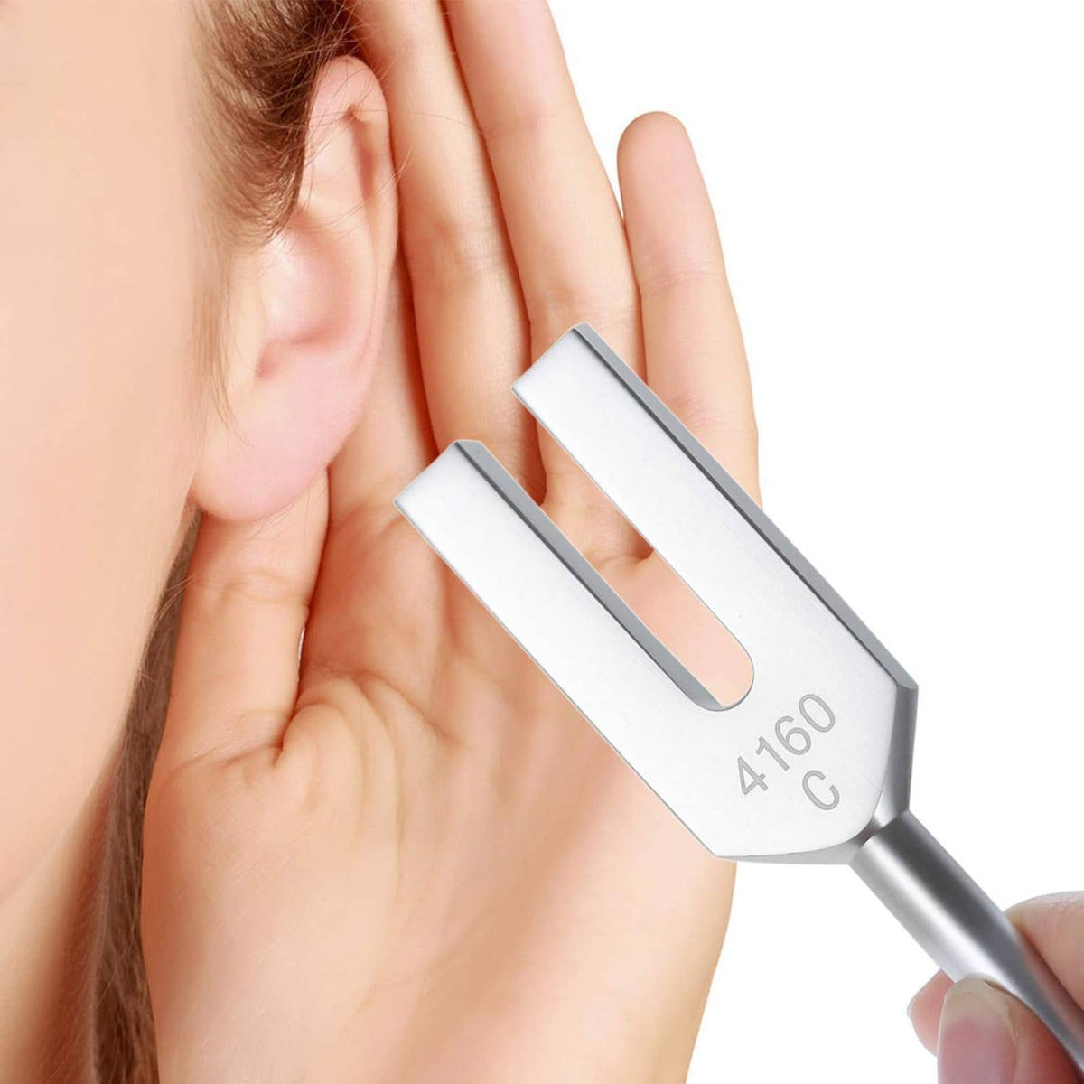 Tuning fork held near ear, with engraving A160 C visible