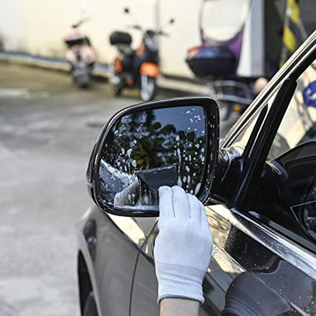 Black squeegee tool wiping a car side mirror surface