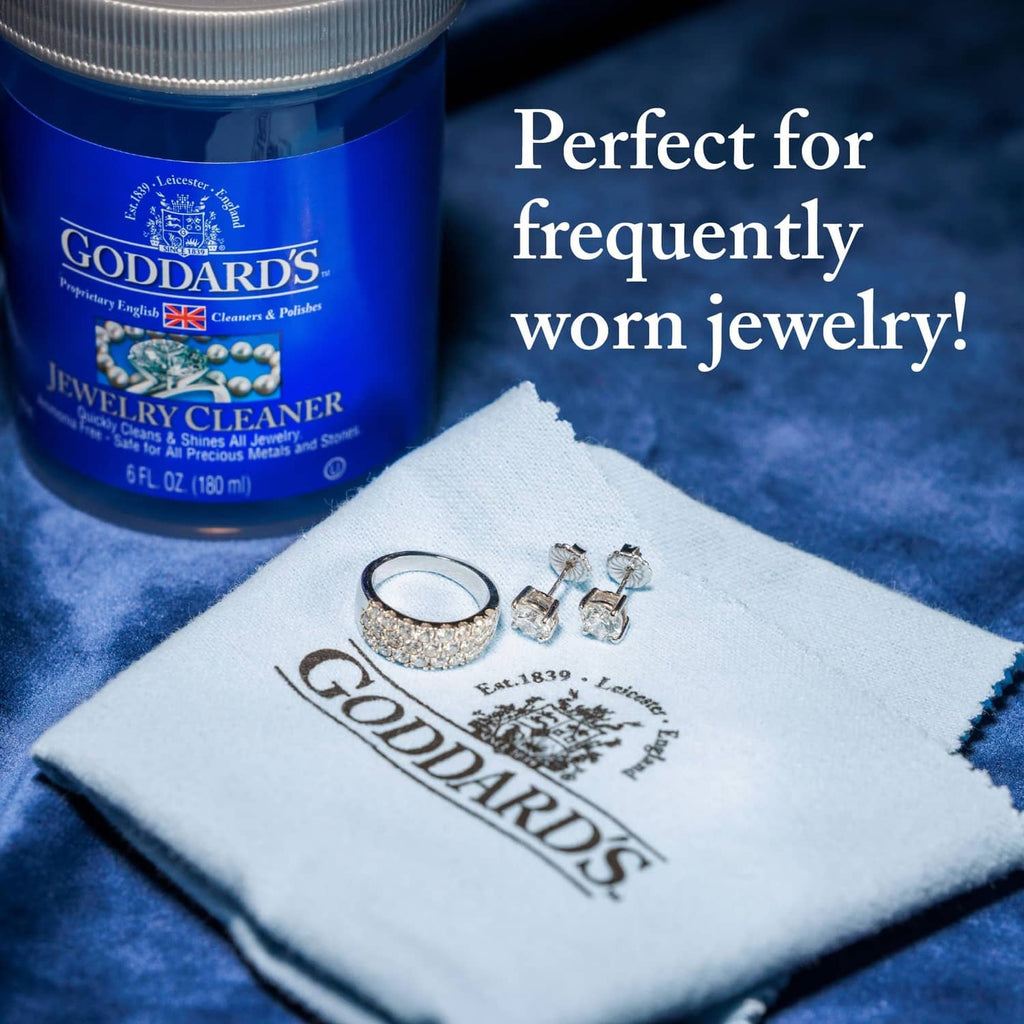 White silver polishing cloth with Goddards logo and small jewelry pieces