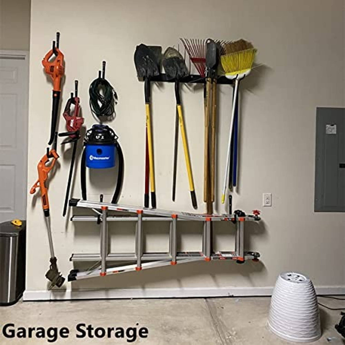 Wall-mounted garage storage hooks holding tools with black U-shaped hook arms