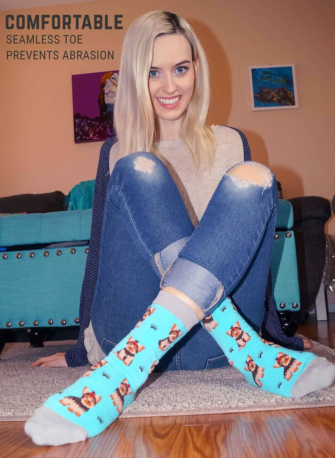 Light blue crew socks featuring yorkie dogs and paw prints on a sitting model